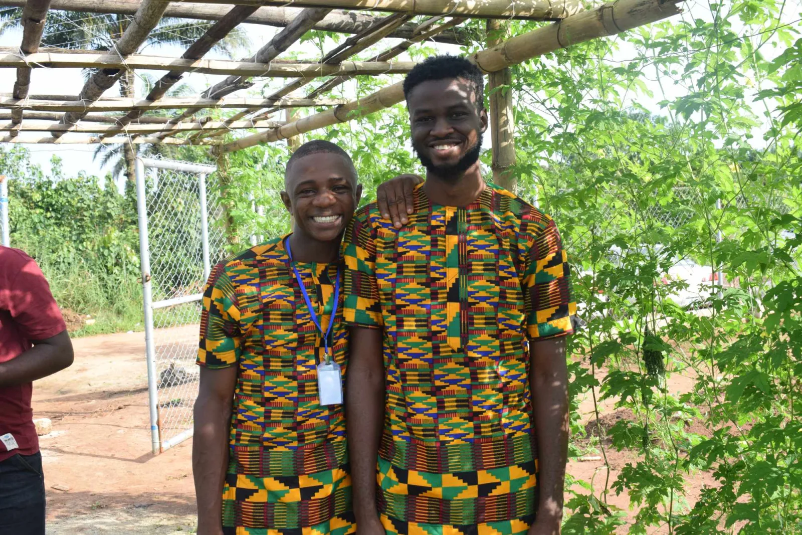 Two K.A.I. trainees under a farm pergola