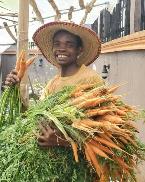 K.A.I. trainee holding a carrot harvest